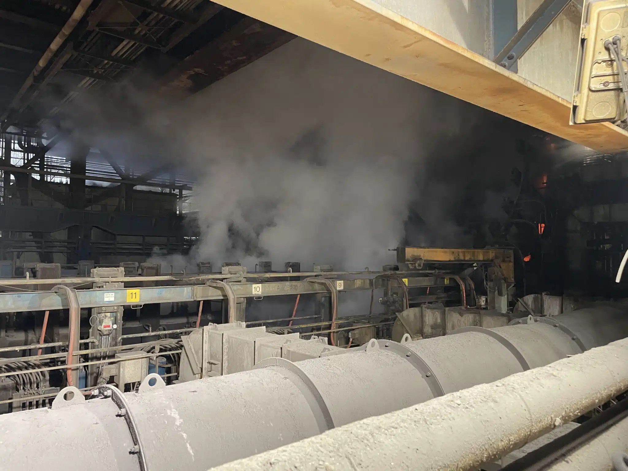 Vista cercana de los equipos de una línea de colada continua con emisiones de vapor