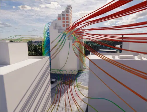Simulación CFD 3D — líneas de corriente coloreadas por velocidad al pie de un edificio alto en entorno urbano denso